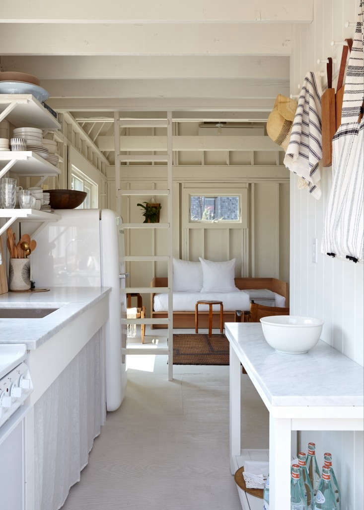 A white sink skirt conceals what’s stored underneath. Opposite it, the couple made use of the narrow space by introducing an Ikea hack—the $129 Rekarne pine console painted Benjamin Moore China White and fitted with a honed Carrara marble top. The Rekarne is no longer available in US stores. For a similar look, try the Havsta sideboard; $199.99 at Ikea.