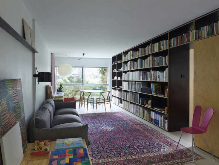 The shelves act like the apartment’s spine, providing a structured backdrop for living.