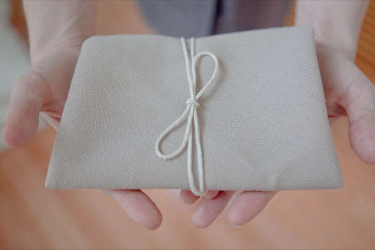 Tie up the package with string, and you have a nice protective cloth for your gift card.