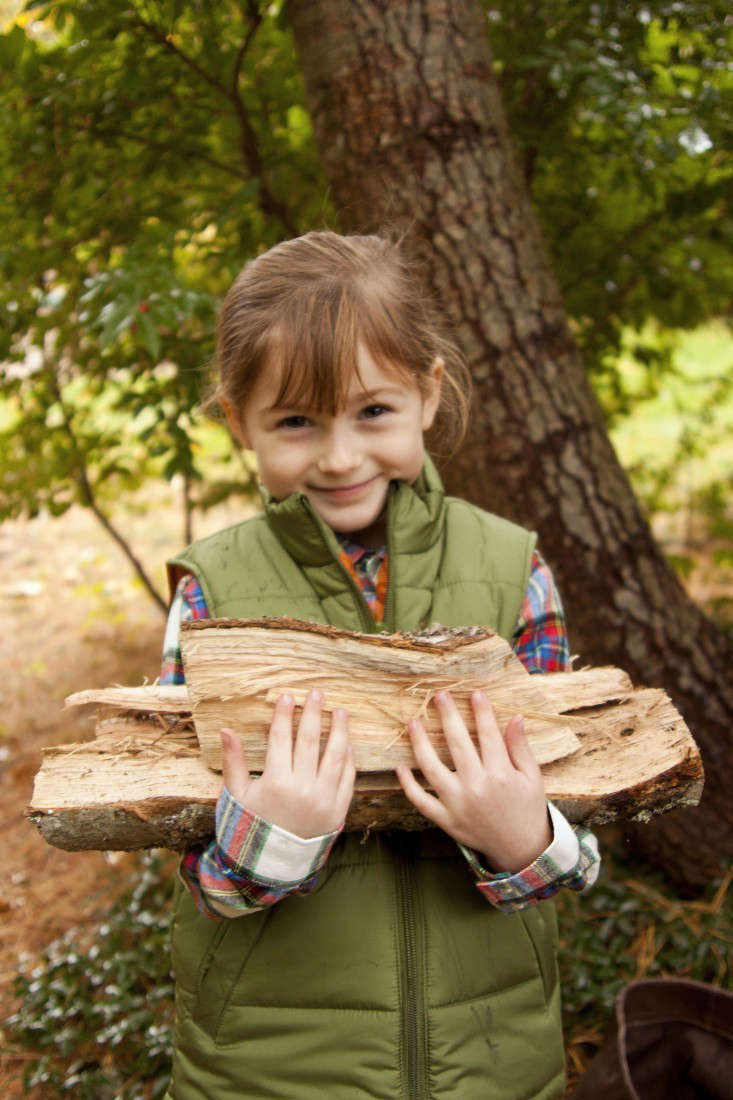 Get kids to pitch in around the house; this young girl is helping to build a cozy fire. Photograph by Sarah Jagger.