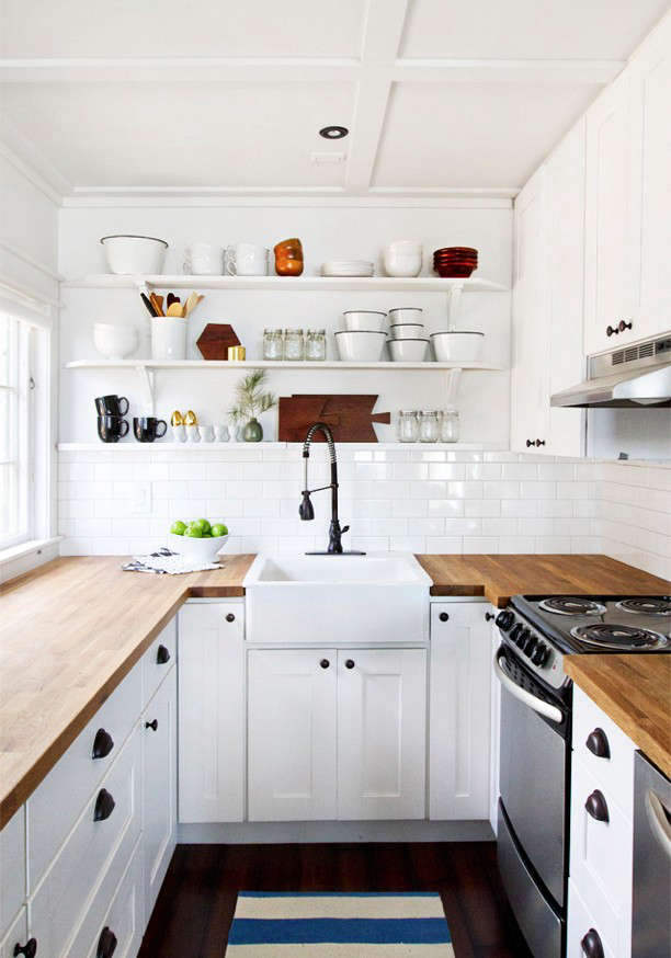 A butler’s sink and overhead open shelves provide the focus in designer and blogger Sarah Sherman Samuel’s small cabin kitchen on the shores of Lake Michigan. Image via Smitten Studio. (N.B.: Have a look at Sarah’s newly remodeled kitchen in LA employing what she calls “the ultimate Ikea hack”: Ikea cabinets and custom doors).