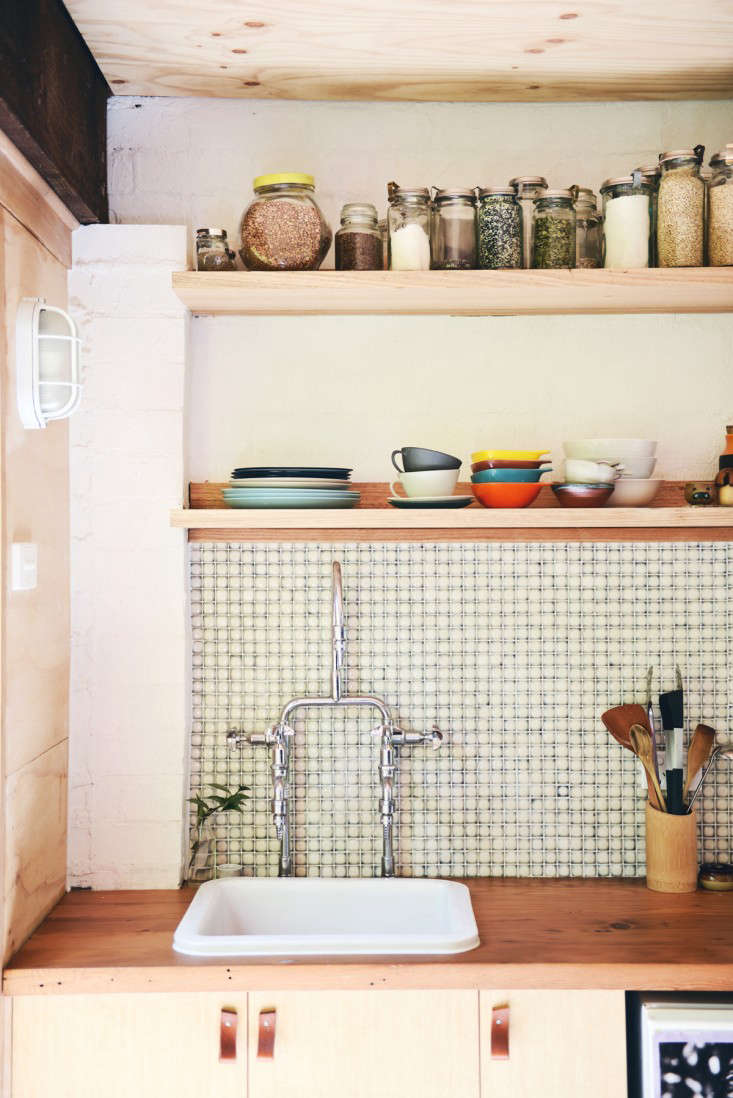 Simple shelving and low-profile bulkhead lighting details in the kitchen. (See 10 Easy Pieces: Outdoor Bulkhead Lighting for similar fixture options.)