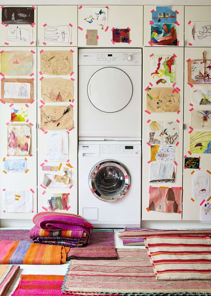 A wall of Ikea cabinetry surrounding a stacked washer/dryer unit has the look of custom built-ins in this laundry area. Photograph by Dana Gallagher, styling by Helen Crowther, from Embrace the Bright: A Textile Shop Owner at Home in Brooklyn.