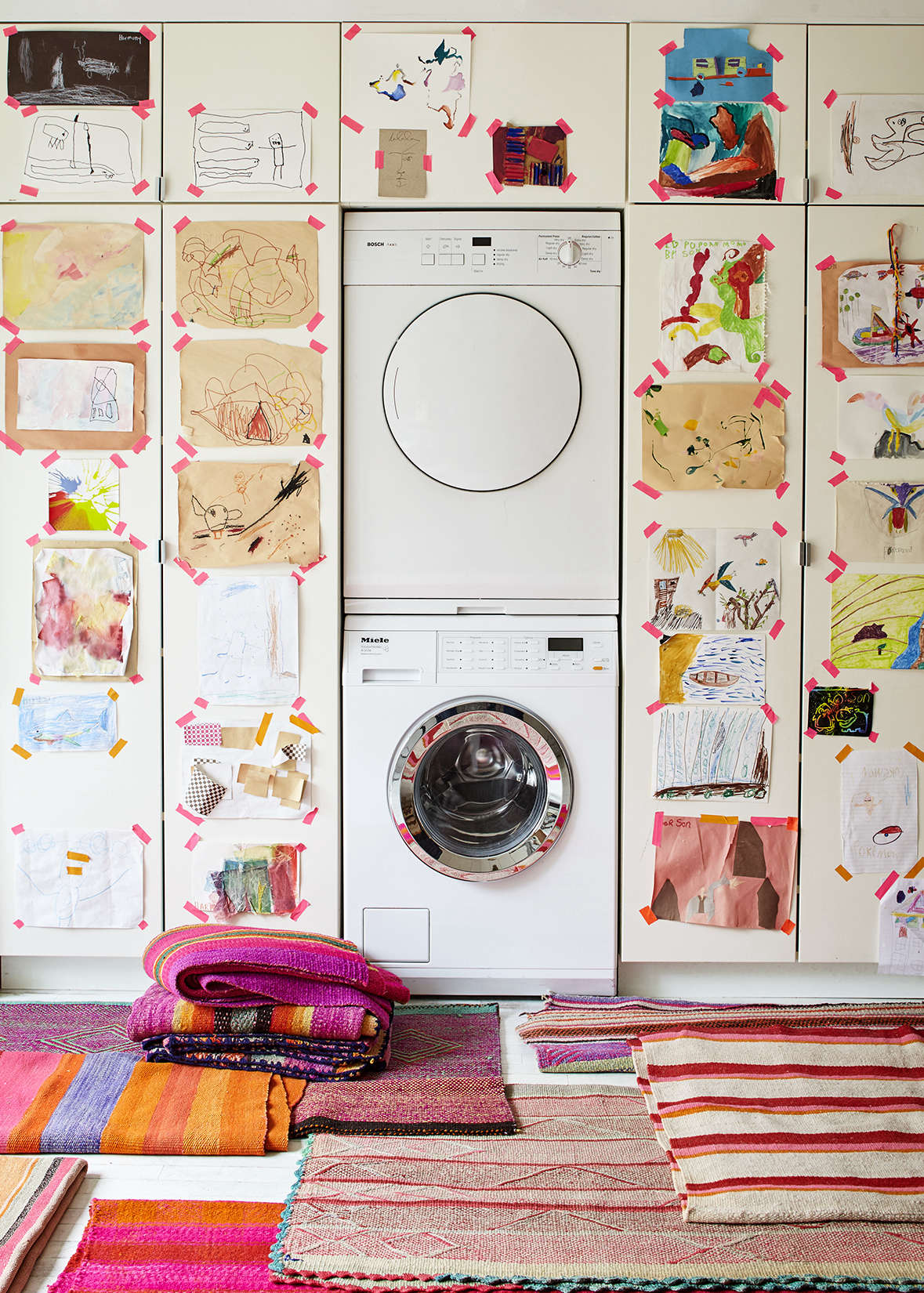 A washer and dryer, both in white, are camouflaged among white Ikea kitchen cabinets. Photograph by Dana Gallagher and styling by Helen Crowther, from Embrace the Bright: A Textile Shop Owner at Home in Brooklyn.