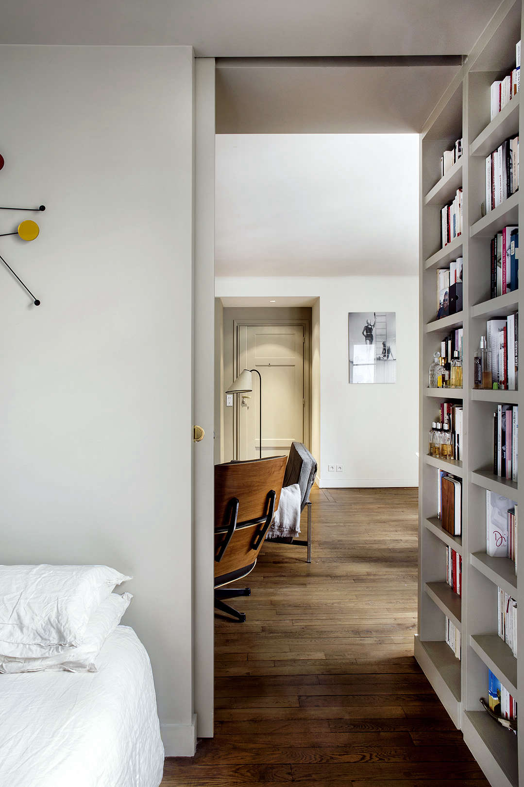 Small Apartment Bedroom With Pocket Door And Wraparound Bookshelves Philippe Harden Design