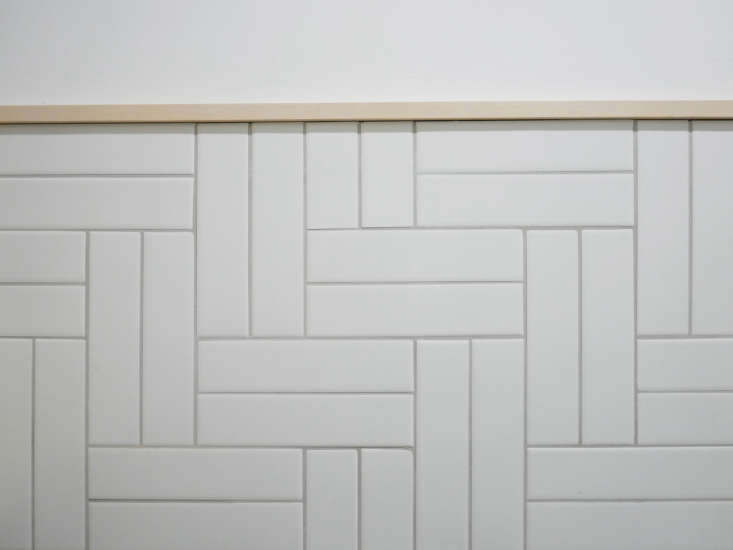 A bathroom wainscot of rectangular ceramic field tile.