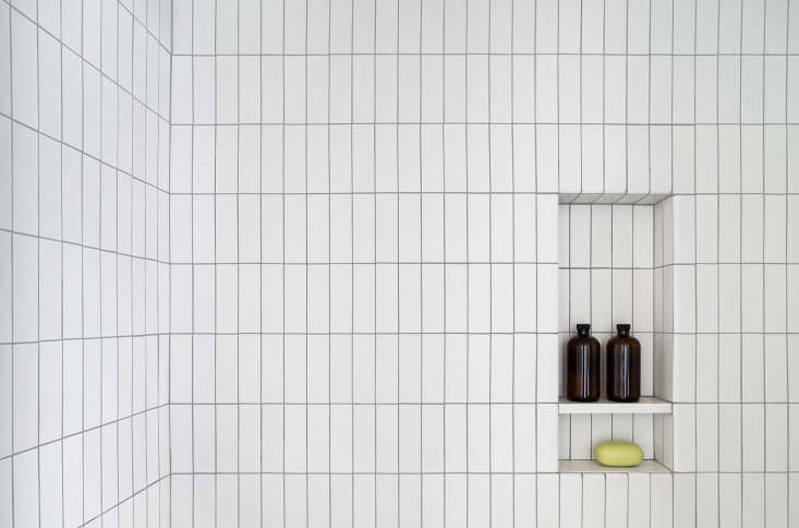 In the shower, white field tile from Heath Ceramics is installed vertically.