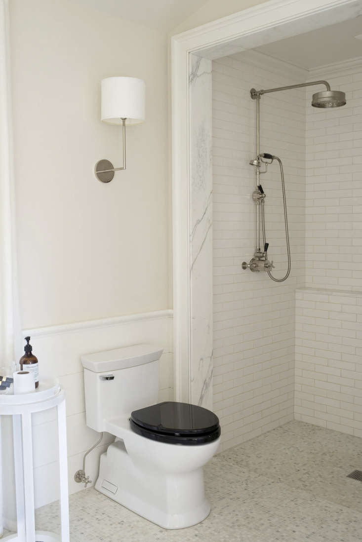 The bathroom floor tile is half-inch Carrara marble, and the shower fixture is also from Lefroy Brooks.