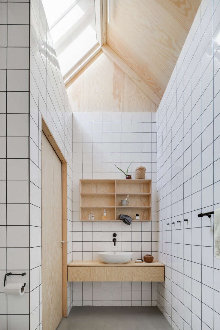 The utilitarian tiled bathroom has plywood components.