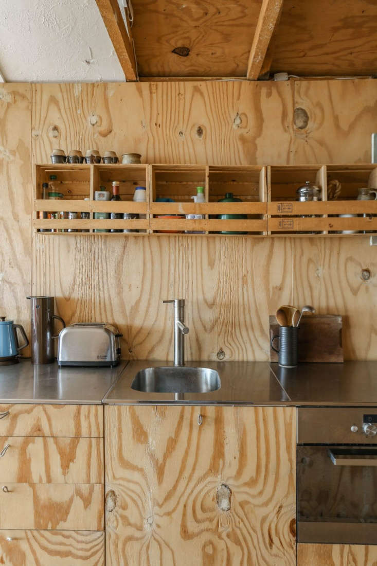 A plywood-lined Ikea hack tiny kitchen in Marcia Mihotich and Durrell Bishop's Seasalter beach house. Photo via The Modern House.