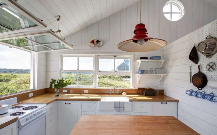 The light fixtures are all vintage; a double sconce from Amsterdam and a red barn light from 1st Dibs (for something similar, look to Barn Light Electric).The countertops are oak finished with a marine varnish. On the white electric range sits a Kaiko One-Handle Pan by Japanese designer Makoto Koizumi.