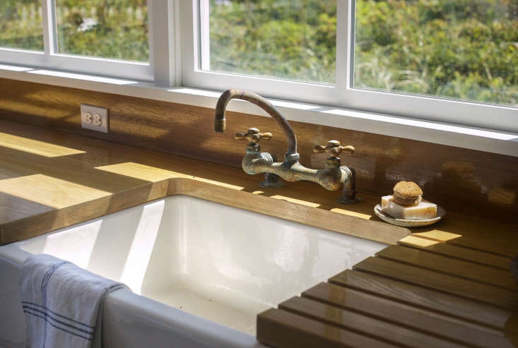 A deck-mounted utility Chicago faucet was stripped down to reveal the brass construction and paired with a ceramic farmhouse sink. (A similar sink is the Shaw’s 30-Inch Original 3018 Fireclay Apron-Front Sink from Rohl. For more, see our post 10 Easy Pieces: White Kitchen Farmhouse Sinks.)