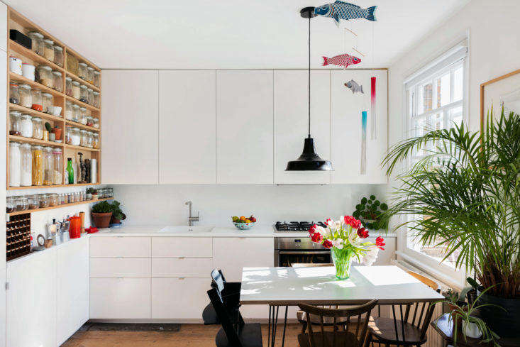 Eat in kitchen with dining table and white Ikea cabinets in London apartment