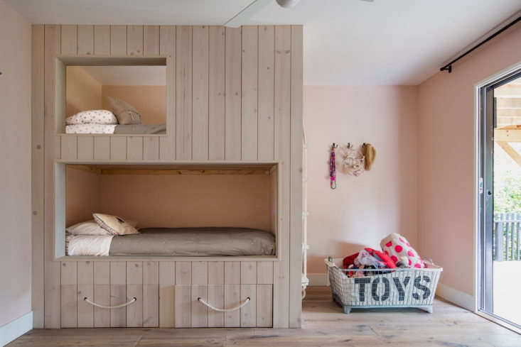  This kids’ room has a built-in, floor-to-ceiling pine wood bunk bed with storage drawers beneath. Photograph by Scott Frances, courtesy of T. W. Ryan Architecture, from A Sixties-Era ‘Builder’s Special’ Reimagined in Montauk.