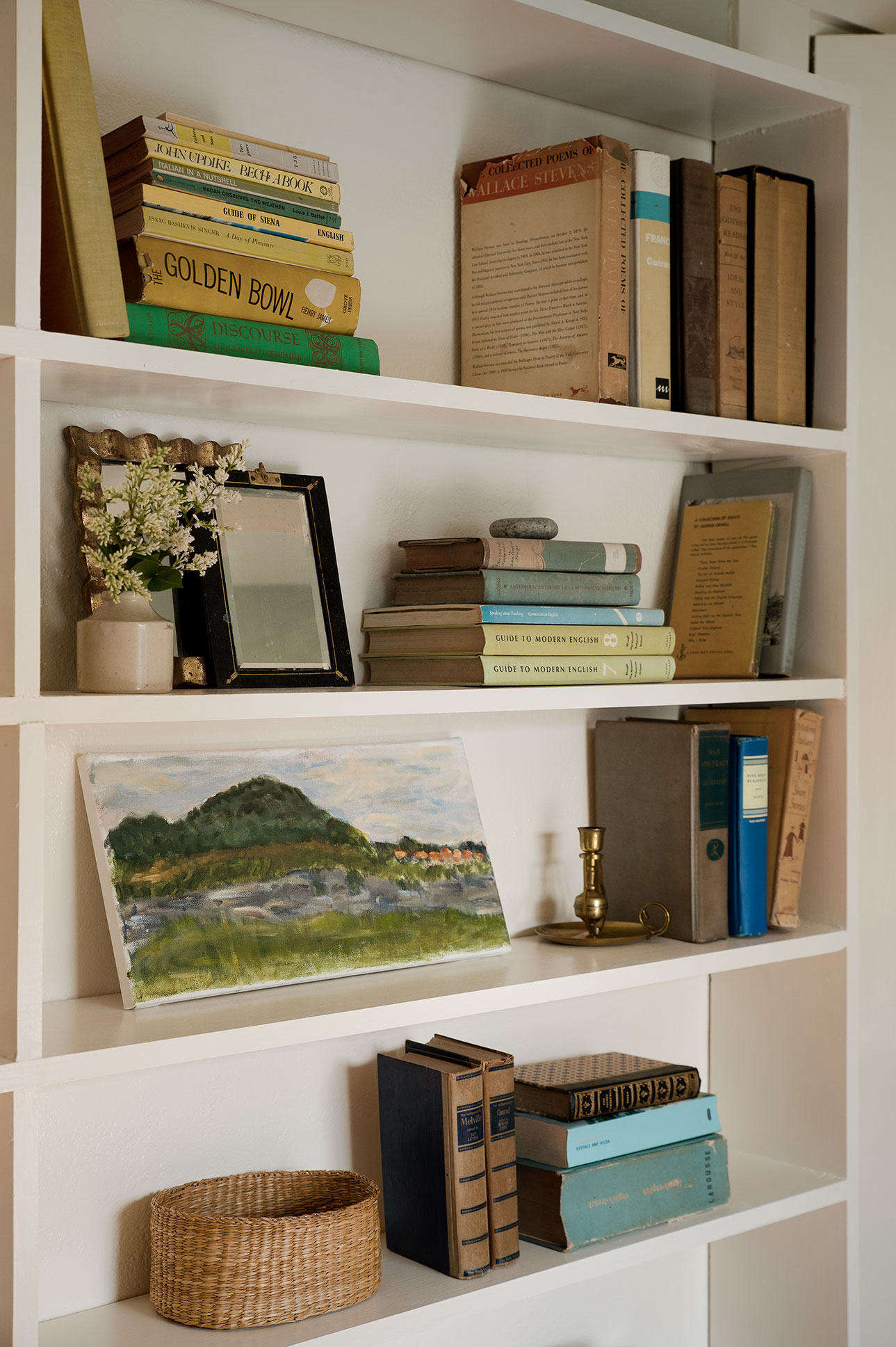 A bookshelf in Julie’s Wellfleet house, post-decluttering. These volumes, as well as a landscape study by her daughter, survived the purge. Photograph by Justine Hand for Remodelista, from Before & After: A Low-Cost Summer Guest Room Makeover, Cape Cod Edition.