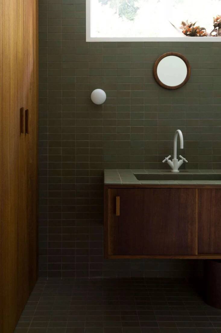 This bathroom, on the North Shore of Auckland, NZ, was designed by Katie Lockhart and features a console made from sustainably sourced Iroko wood and Heath Ceramics 2-by-4-Inch Tiles in “Soapstone”. Read more about this bathroom in Bathroom of the Week: Two Bath Remodels with Bold Green Tile in Auckland. Photo by Neeve Woodward, courtesy of Katie Lockhart Studio.