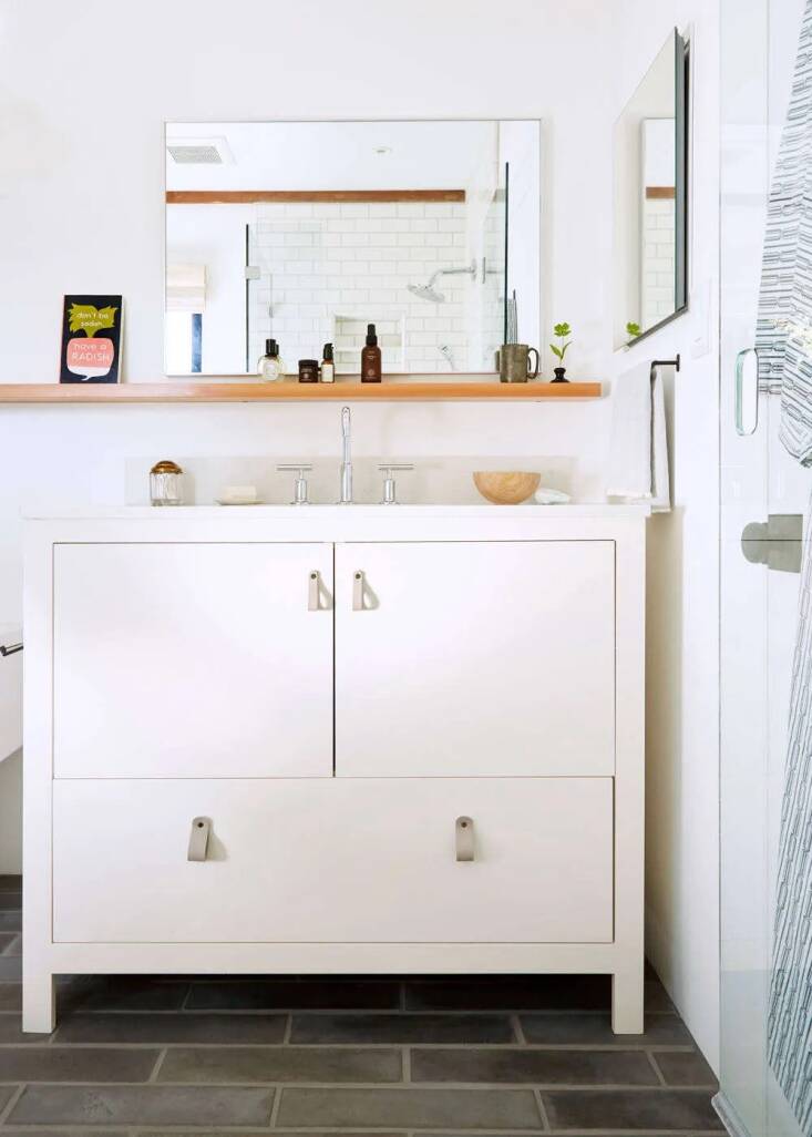 A simple white vanity with gray leather drawer pulls in photographer Katie Baum’s Monte Rio home, designed by Lola Home Design. Read more in Bathroom of the Week: A Spa-Like Sanctuary in a Sonoma County Cottage. Photo by Aya Brackett.