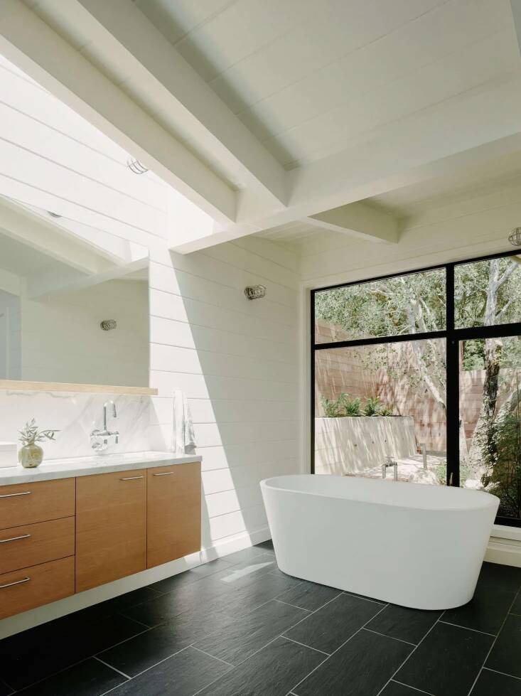 A wooden bathroom vanity console with a marble top in architect Malcolm Davis’s Portola Valley home. See more of the home in California Idyll: A Pitched-Roof Midcentury Revival with Dramatic Valley Views. Photo by Joe Fletcher, courtesy of Malcolm Davis Architecture.